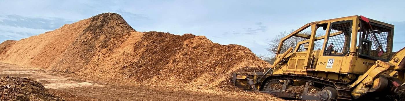 A tractor scooping up wood by products